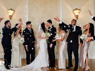 bridal party throwing flowers bride and groom kissing