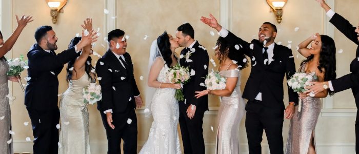 bridal party throwing flowers bride and groom kissing