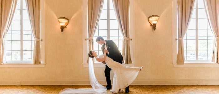 groom leaning bride back in ballroom