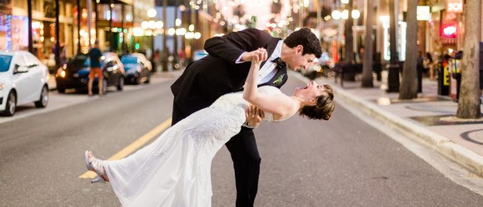 groom leaning bride back for a kiss in the road